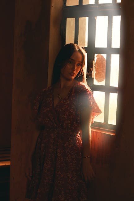 Woman in a peaceful yoga pose in a bright, serene room with warm sunlight.